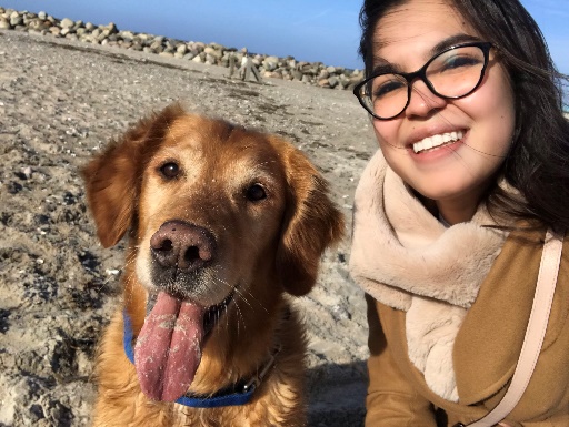 Photo d'Élisabeth sur une plage danoise, accompagnée d'un chien super photogénique (Il tire la langue !)